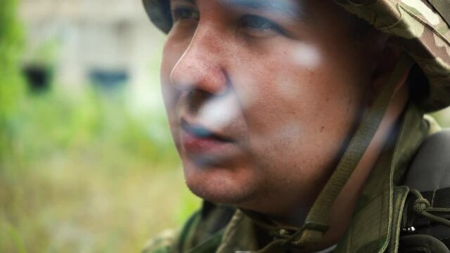 a man in camouflage uniforms smokes a cigarette at a halt