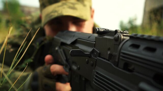 man aiming from a rifle in a prone position close-up