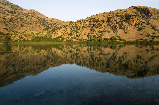 Mountain lake landscape with reflection in water at sunrise