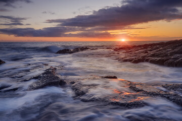 Naklejka premium Rathmoylan Cove, Waterford, Ireland. Stunning rocks and sunset.