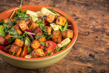 Salad with vegetables, arugula, avocado and fried tofu - close-up, copy space, modern vegetarian healthy cuisine, vegan keto diet