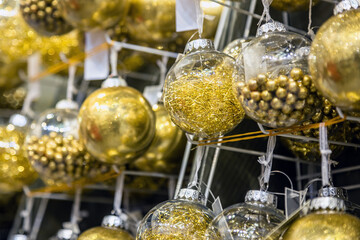 Fototapeta na wymiar Christmas ball hangs on a shelf in the store among other Christmas toys