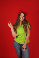 a young beautiful girl with long hair with a red bow on her head in a light green T-shirt in blue...