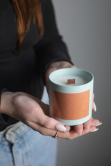 candle with a wooden wick in hand. mock-up packaging
