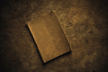 An old brown book with a clean cover without an inscription on a vintage wooden table. Retro style.