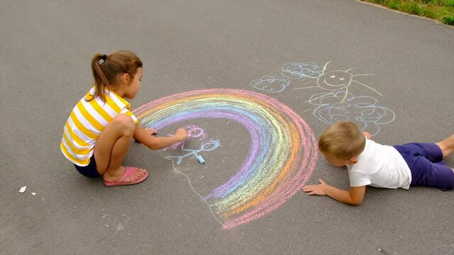 Children draw with chalk on the asphalt. Selective focus.