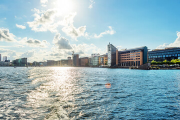 Naklejka premium Beautiful modern buildings on the bank of the canal in Copenhagen, Denmark.Sun, beautiful clouds. Contemporary European architecture. Architecture.