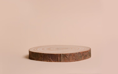 Round wooden shape of a saw cut tree on a beige background. Empty stage showcase for your product presentation.Сopy space for text.