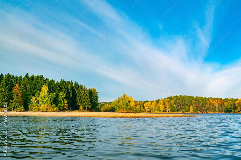 Canvas Prints Panoramic view of the bright colorful trees along the bank of the Kama River Russia Perm Krai. Autumn colored trees and blue sky, reflected in the calm and shiny water.