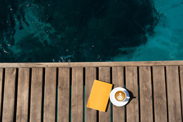 book and coffee cup on wooden background