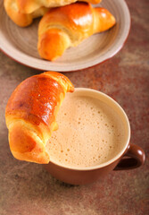 Fresh yeast crescents with cup of coffee