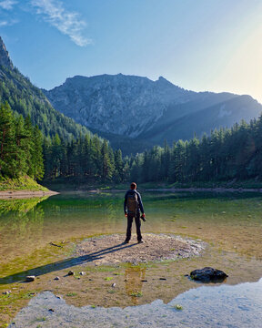 Calm lake in the alps in the morning with photographer