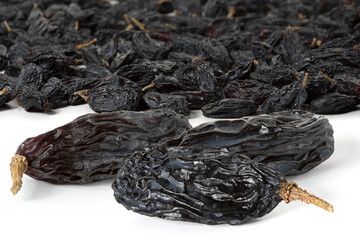 Many berries of black raisins dried in shade on a white background. Front view. With clipping path