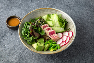 Buddha bowl with tuna, avocado, green beans, cucumber. Diet healthy nutritious food. Ready menu for the restaurant. Neutral gray blue textured background