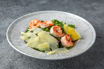 Hearty salad with shrimps, tomatoes, lettuce, sauce. Diet food. Ready menu for the restaurant. Neutral gray blue textured background