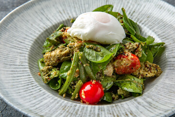 Salad with spinach, eggplant, tomatoes, poached eggs. Diet healthy nutritious food. Ready menu for the restaurant. Neutral gray blue textured background