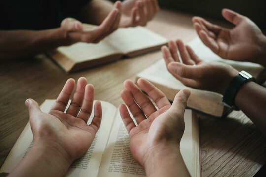 Christians are congregants join hands to pray and seek the blessings of God. Devotional or prayer meeting concept.