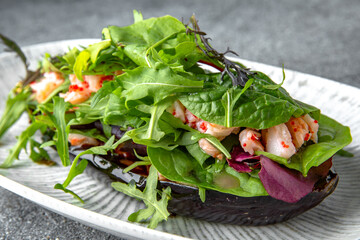 Baked eggplant with arugula, shrimps, tobiko caviar pate. Ready menu for the restaurant. Neutral gray blue textured background