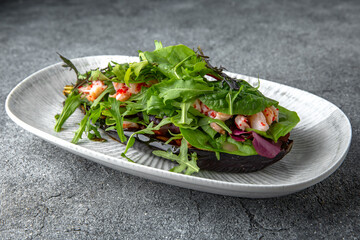 Baked eggplant with arugula, shrimps, tobiko caviar pate. Ready menu for the restaurant. Neutral gray blue textured background