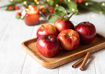 Autumn background with apples, cinnamon, hawthorn and christmas lights