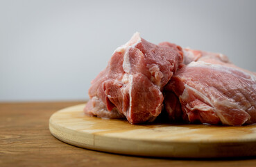 Mięso z łopatki wieprzowej bez kości. Surowe mięso leżące na drewnianej desce. Idealne mięso do gulaszu.  - obrazy, fototapety, plakaty