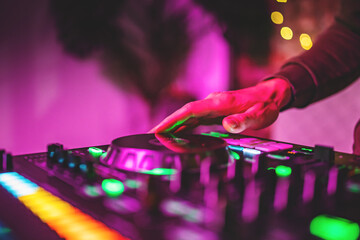 DJ Hands creating and regulating music on dj console mixer in concert nightclub