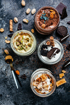 assorted ice cream served in a glass jar, italian dessert gelato pistachio, chocolate, caramel, oreo cookies, vertical image. top view