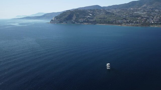 ripresa con drone dall'alto di barca a motore mentre orbita in torno e svela il paesaggio