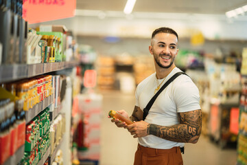 Chico atlético fitness tatuado comprando en un supermercado