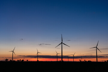 Fototapeta na wymiar Production of electrical energy with wind mills in a sustainable way with renewable energies at sunset