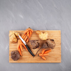 Different Ugly vegetables (potato; carrot; beetroot) on cutting board, top view. Concept - Food...