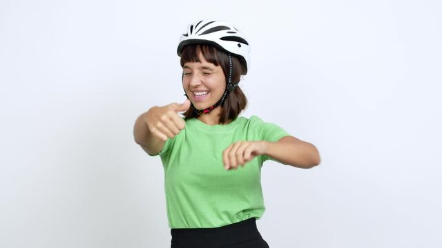Young woman with bike helmet over isolated background giving thumbs up and smiling because something good has happened over isolated background