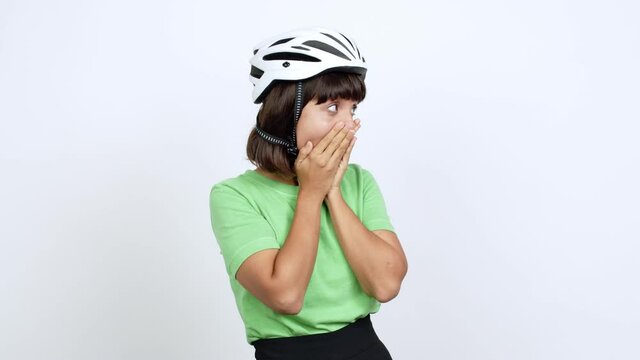Young woman with bike helmet over isolated background covering mouth with hands. Can not speak over isolated background