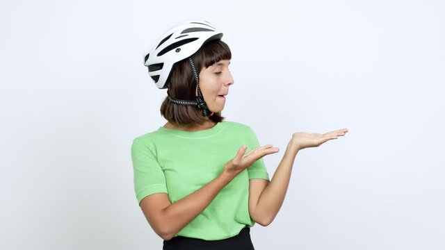 Young woman with bike helmet over isolated background extending hands to the side and inviting to come over isolated background