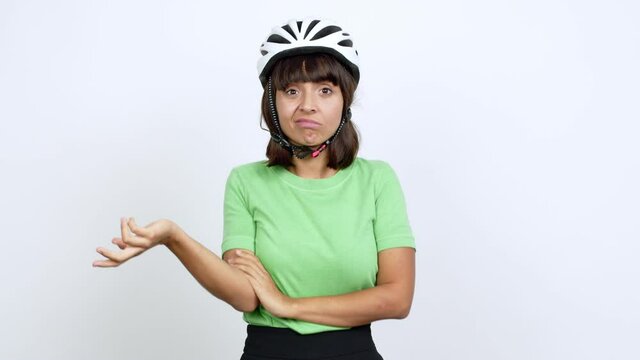Young woman with bike helmet over isolated background having doubts over isolated background