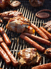 Cooking and roasting pork, beef, chicken meat and sausages on the grill. Picnic with barbecue on the outdoor nature background