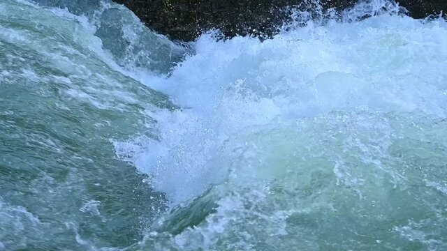 Slow motion of a white water stream on a river after heavy rain	
