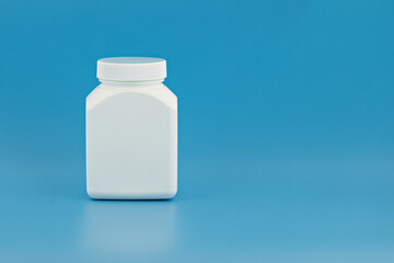 medical jar template for branding, text and design. white unbranded jar on blue background. medical bottle mockup with copy space