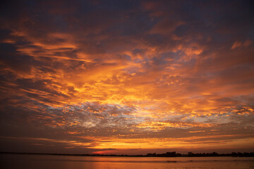 Scenic view dramatic beautiful sunset sky. Natural Sunset Sunrise on meadow silhouette shadow dark land. Vibrant dramatic sky on sunset, dawn, sunrise in Countryside. Landscape Colorful Sky At Sunset