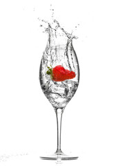 Strawberry splashing into an ice-cold cocktail glass isolated on white background