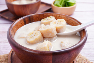 Banana in coconut milk, on a wooden cup of Thai dessert