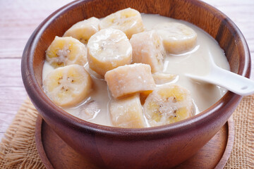 Banana in coconut milk, on a wooden cup of Thai dessert