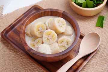 Banana in coconut milk, on a wooden cup of Thai dessert