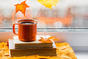 Autumn still life with a beautiful bokeh. Outside the window, maple leaves and raindrops are...