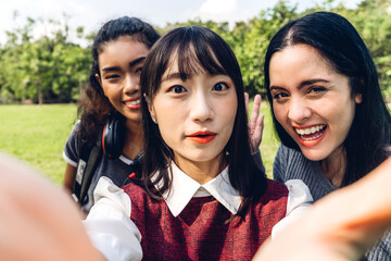 Smiling group of friend woman international student or teenager standing and look at camera making live selfie on smartphone in travel vacation summer park.selfie time and friendship Concept