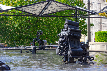 Playful trick fountains at Fasnachtsbrunnen (carnival fountain), also called Tinguely Brunnen (Tinguely fountain), in Theaterstrasse (theatre street) in Basel, Switzerland, on a beautiful sunny day