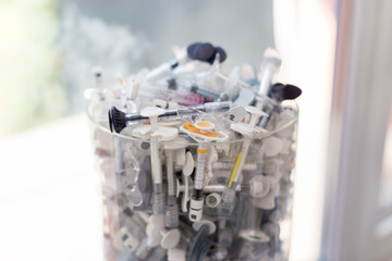 a lot of used syringes on a glass vial in a medical center, beautiful art