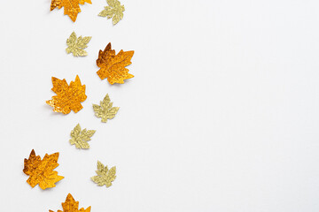 Golden maple leaves decorations on white background. Autumn, fall concept. Flat lay, top view, overhead