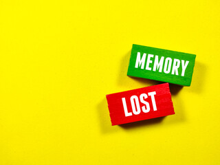 Colored wooden cube written with text MEMORY LOST on a yellow background.