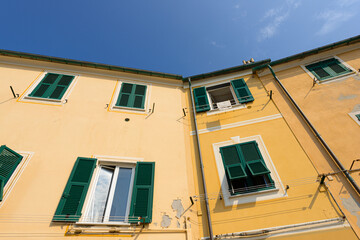 Traditional colors of the house, walls, doors, windows. Italy. - 459276366